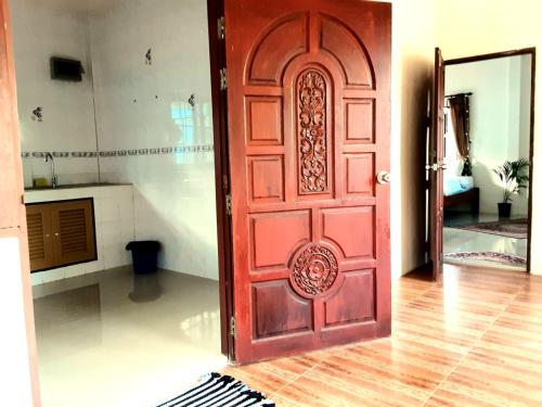 Haad Chao PhaoCentral Essence的带厨房的房间里一扇红色的门