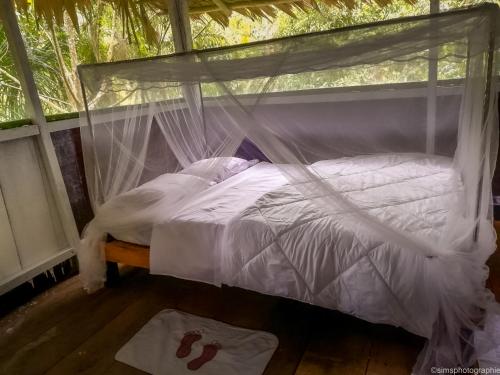 伊基托斯MALOKA LODGE的一间卧室配有一张带蚊帐的床