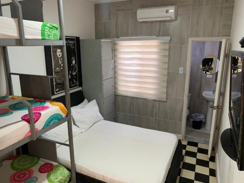 巴兰基亚Hostel Mamy Dorme的小房间设有两张双层床和窗户