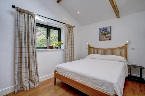 哈勒斯登Contemporary Barn Waveney Valley的一间卧室设有一张床和一个窗口