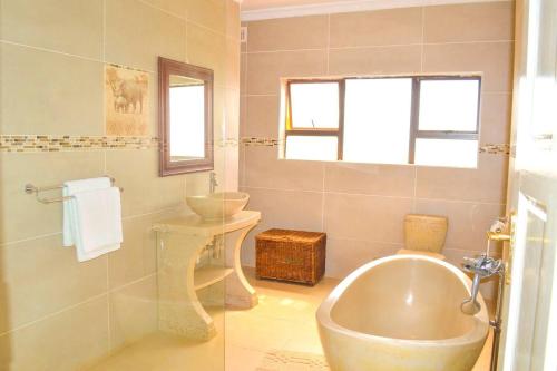 KingsmeadMt Pleasant - 4-Bed Villa in Harare Solar Power的带浴缸、盥洗盆和卫生间的浴室