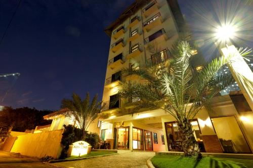宿务阿尔巴吾诺酒店的前面有棕榈树的建筑