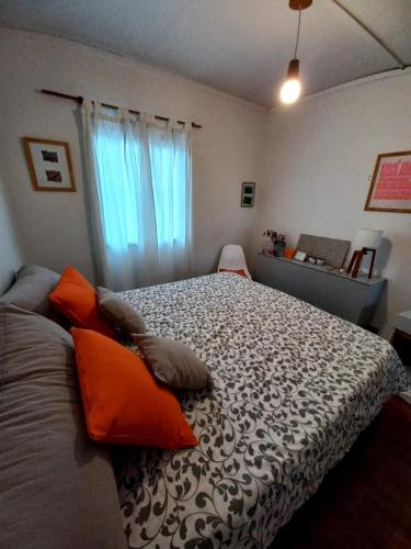 乌斯怀亚Habitación con Baño Privado - Frigo bar y sector para desayunar - Sin cocina的一间卧室配有一张带橙色枕头的大床