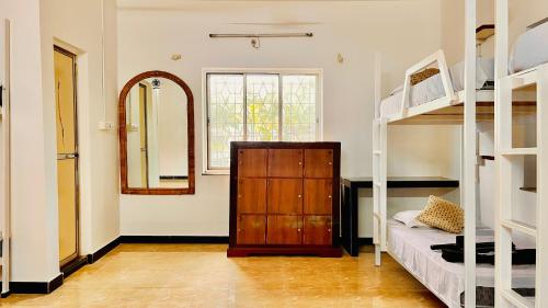 瓦加托Mitra Hostel (By The Pool)的客房设有两张双层床和镜子
