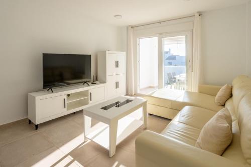 萨阿拉德洛斯阿图内斯Playa Blanca Zahara的带沙发和电视的客厅