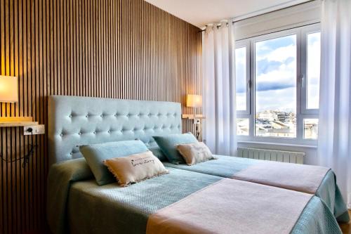 卢戈Muralla & Views的一间卧室设有一张大床和大窗户