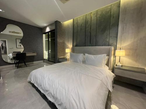 利雅德برج كابانا للوحدات السكنية的卧室配有一张白色大床和一张书桌