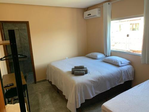 伊比科阿拉Pousada Licuri Ibicoara的一间卧室配有一张带两个枕头和镜子的床