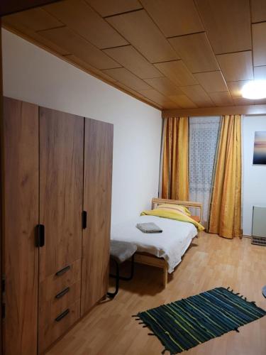 米尔茨楚施拉格Ferienwohnung Max的一间卧室配有一张床和一个大型木制橱柜