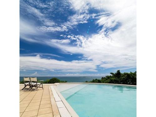 宇流麻Hotel Hamahigashima Resort - Vacation STAY 10570v的一个带两把椅子的游泳池以及大海