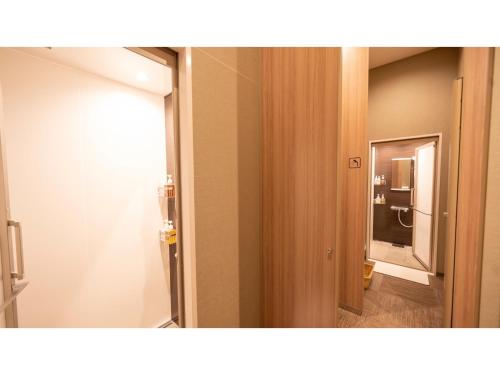 俱知安町TORIFITO HOTEL&POD NISEKO - Vacation STAY 81523v的一间带镜子的浴室和一扇通往客房的门