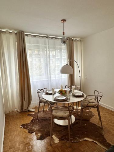 布洛涅-比扬古Appartement neuf à boulogne à 3 mins à pieds du métro的一间带桌椅和窗户的用餐室