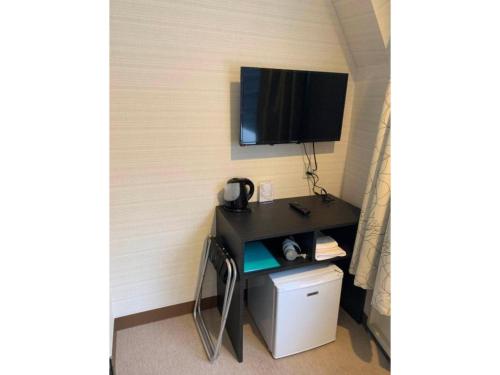 东京Tabata Oji Hotel - Vacation STAY 89847v的客房设有一张桌子,墙上配有电视