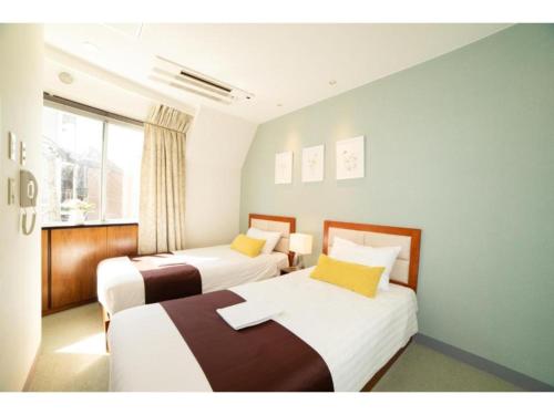 东京Tabata Oji Hotel - Vacation STAY 89843v的小型客房 - 带2张床和窗户