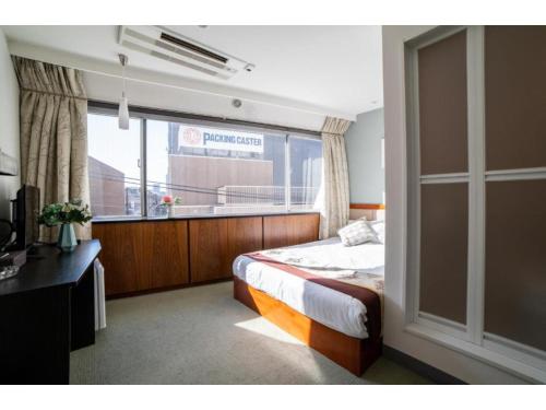 东京Tabata Oji Hotel - Vacation STAY 89820v的一间卧室设有一张床和一个大窗户