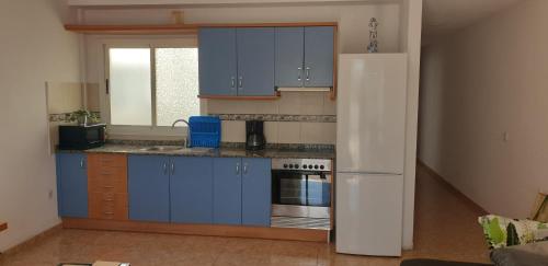 CarrizalÁtico carrizal的厨房配有蓝色橱柜和白色冰箱
