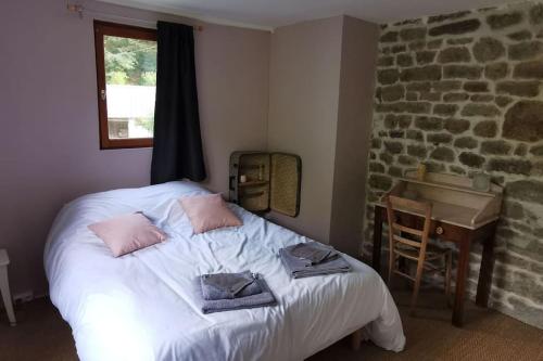 le moulin des riviéres的一间卧室配有一张床、一张桌子和一个窗户。
