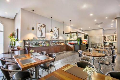 圣保罗Maximus Luxury in Perdizes - Allianz - Flat at the Hotel的一间带桌椅的餐厅和一间酒吧