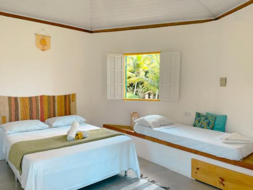库穆鲁沙蒂巴Canto do Mar - Chalés com vista pro Mar - Cumuruxatiba的一间卧室设有两张床和窗户。