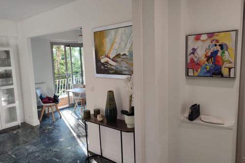 昂蒂布BNB RENTING Brand new 2 bdr apartment in Antibes的客厅配有桌子和墙上的绘画