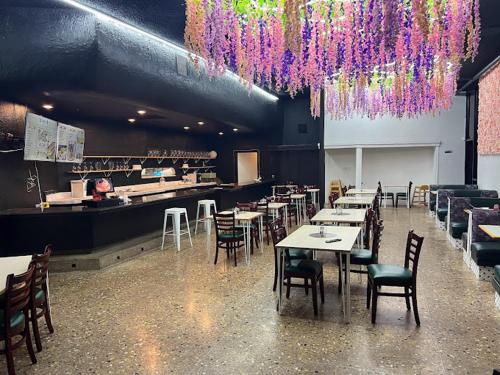 奥克兰Garden Inn & Suites Oakland Airport的餐厅设有桌椅和紫色吊灯。