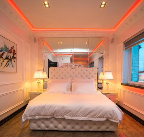 凯夫拉维克Diamond Suites by Reykjavik Keflavik Airport的一间卧室配有一张带两盏灯的大型白色床。