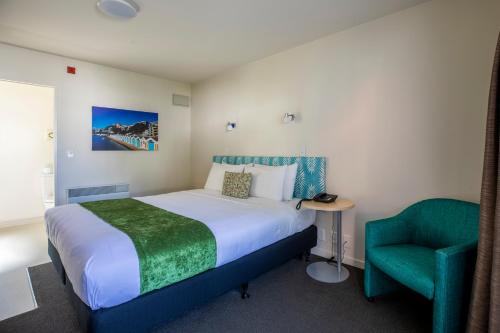 惠灵顿贝亚维斯塔汽车旅馆－惠灵顿的一间卧室配有一张床和一把绿色椅子