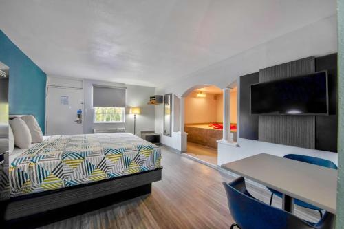 杰克逊Studio 6 Jackson MS I 55的酒店客房带一张床铺、一张书桌和一间卧室