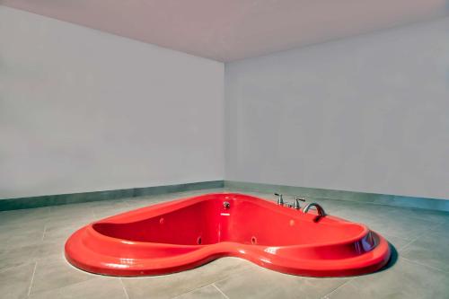 杰克逊Studio 6 Jackson MS I 55的客房内的红色大浴缸
