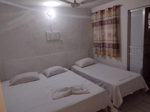 普鲁登特总统城HOTEL ITAVERÁ BRASIL的带窗户的客房内设有两张单人床。