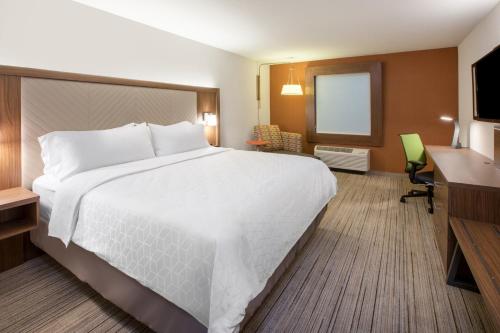 海沃德Holiday Inn Express & Suites Hayward, an IHG Hotel的酒店客房设有一张大床和一张书桌。