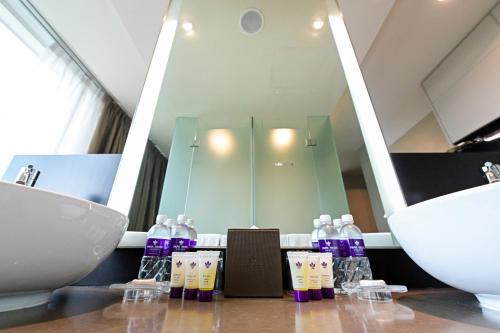新加坡Park Regis Singapore的浴室设有水槽和带肥皂的吧台。