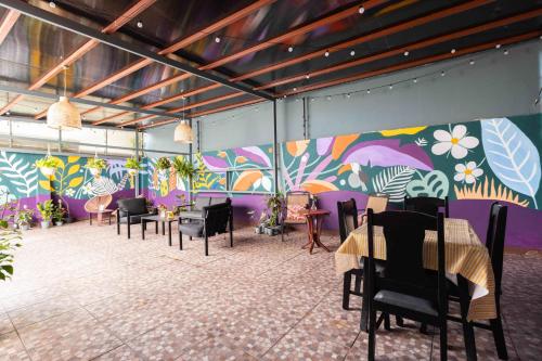 圣何塞Viva Guest House的配有桌椅和彩色墙壁的客房