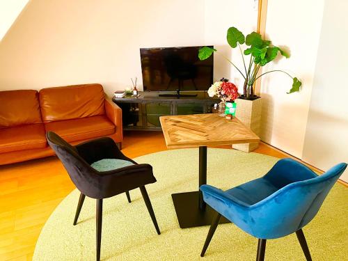 金泽ゲストハウス西金沢Smile&smile的客厅配有两把椅子和一张沙发