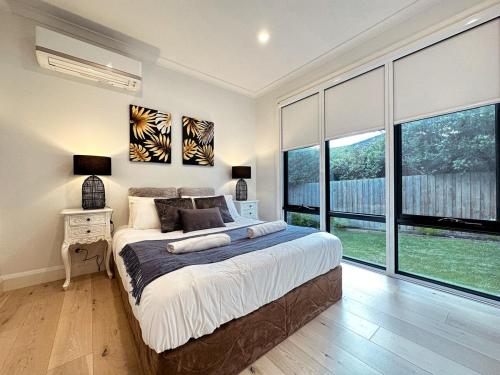 格伦韦弗利Luxury Glen Waverley Townhouse 4br3ba Backyard的一间卧室设有一张大床和大窗户