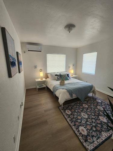 达尼亚滩Hostel Beds & Sheets FLL AIRPORT的一间卧室配有一张带地毯的床和两个窗户