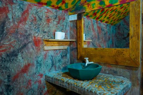 锡吉里亚Elephant Lake Villa的浴室设有蓝色水槽和镜子