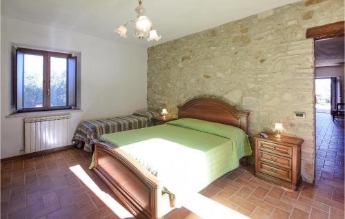 SaraganoNice Apartment In Loc, Saragano, Gualdo With Outdoor Swimming Pool的一间卧室设有一张床和石墙