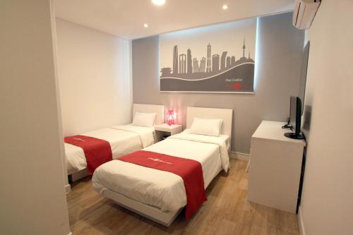 首尔Hotel Unique by Foret的一间酒店客房,设有两张床和电视