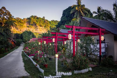 仙本那Timba Garden FREE TOWN AND JETTY TRANSPORT的一座花园,在一座建筑前有红杆