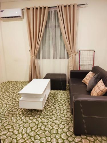 斯里巴加湾市Al Hidayah Suite的带沙发和咖啡桌的客厅