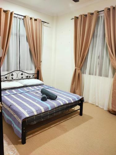 斯里巴加湾市Al Hidayah Suite的一间卧室配有一张带蓝色棉被和窗帘的床
