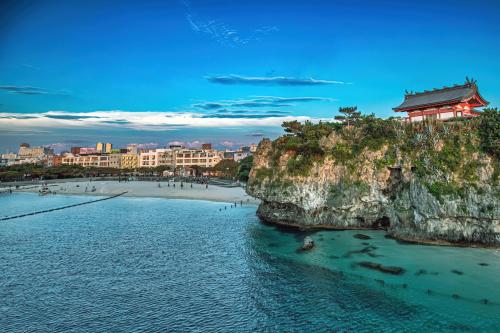 那霸Coral Gate in Kume コーラルゲートイン久米的悬崖上一座建筑的海滩美景