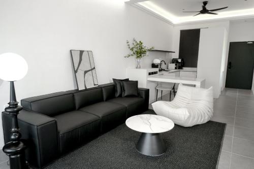 瓜埠Langkawi Homestay at Simfoni Beliza Apartment by Chien的客厅配有黑色沙发和桌子