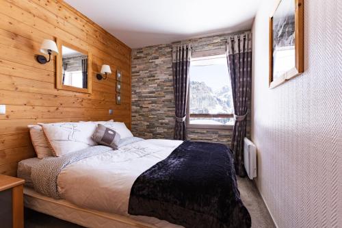 阿沃里亚兹Luxury Chalet with sauna by Avoriaz Chalets的一间卧室设有一张床和砖墙