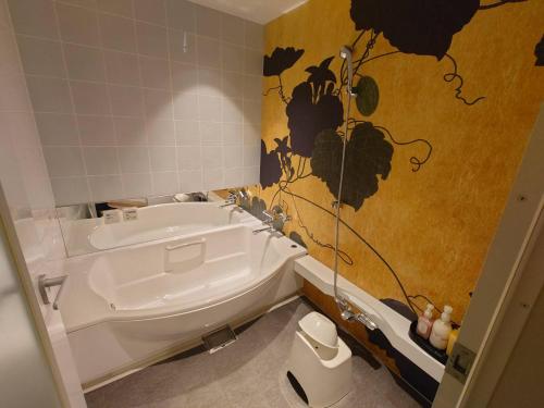 姬路ホテル継kei男塾ホテルグループ的带浴缸和卫生间的浴室。