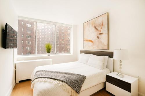 纽约Lovely 2 Bedroom Apartment的白色的卧室设有床和窗户
