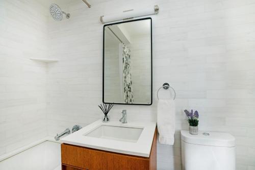 纽约Lovely 2 Bedroom Apartment的白色的浴室设有水槽和镜子