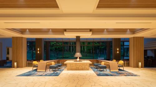 北塩原村EN RESORT Grandeco Hotel的大楼内带桌椅的大堂