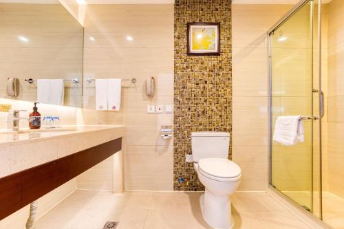 长春长春国盛维景酒店的一间带卫生间和玻璃淋浴间的浴室